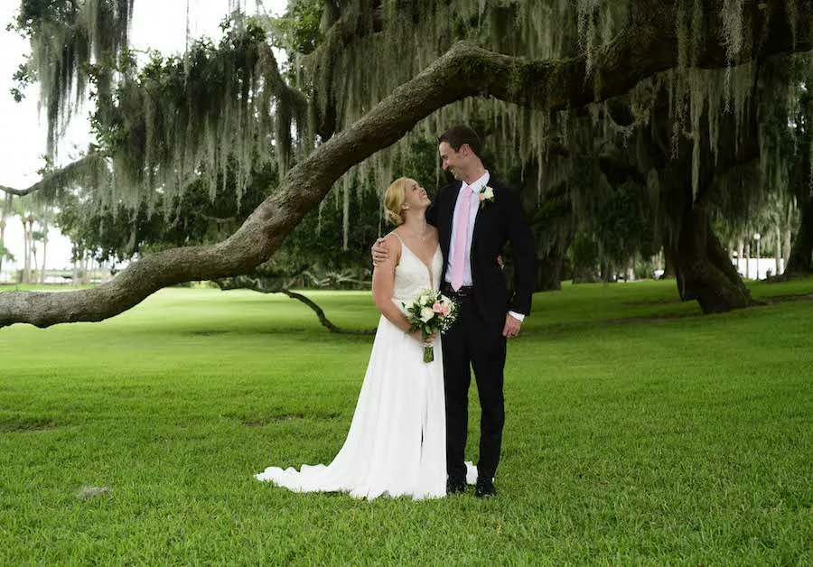 Man and woman in wedding attire under oak tree in Jekyll Island 