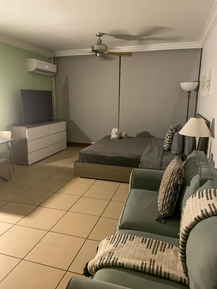 Small room with bed, couch and TV in San Juan, Puerto Rico 