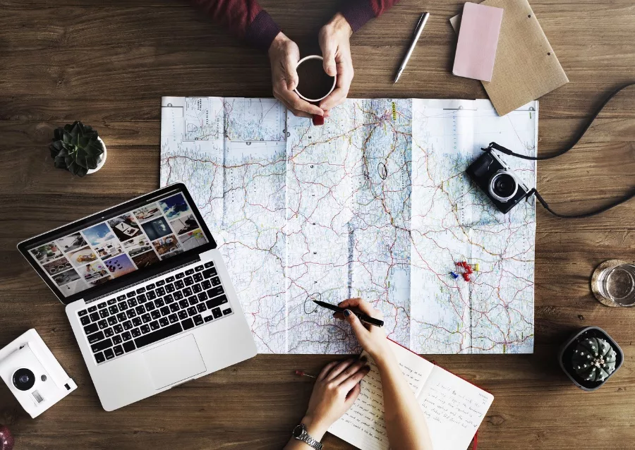 Photo of people planning out a trip with a map - Travel Resources cover photo (stock photo from canva.com by @agero-agnis).