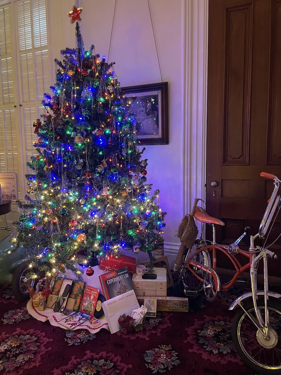 Things to do in Janesville - Brightly lit Christmas tree surrounded by antique bike and toys 
