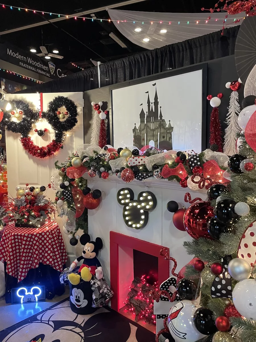 Fireplace mantle decorated with a Mickey and Minnie Mouse theme with a picture of Cinderella's castle above and lots of mickey mouse ears all around. 