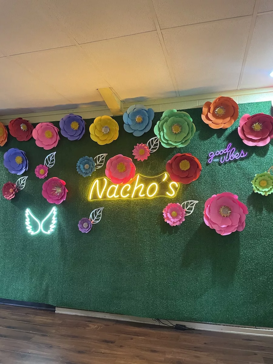 Image of wall for photos with paper flowers and Nacho's sign in the center - Portage Canal Segment 