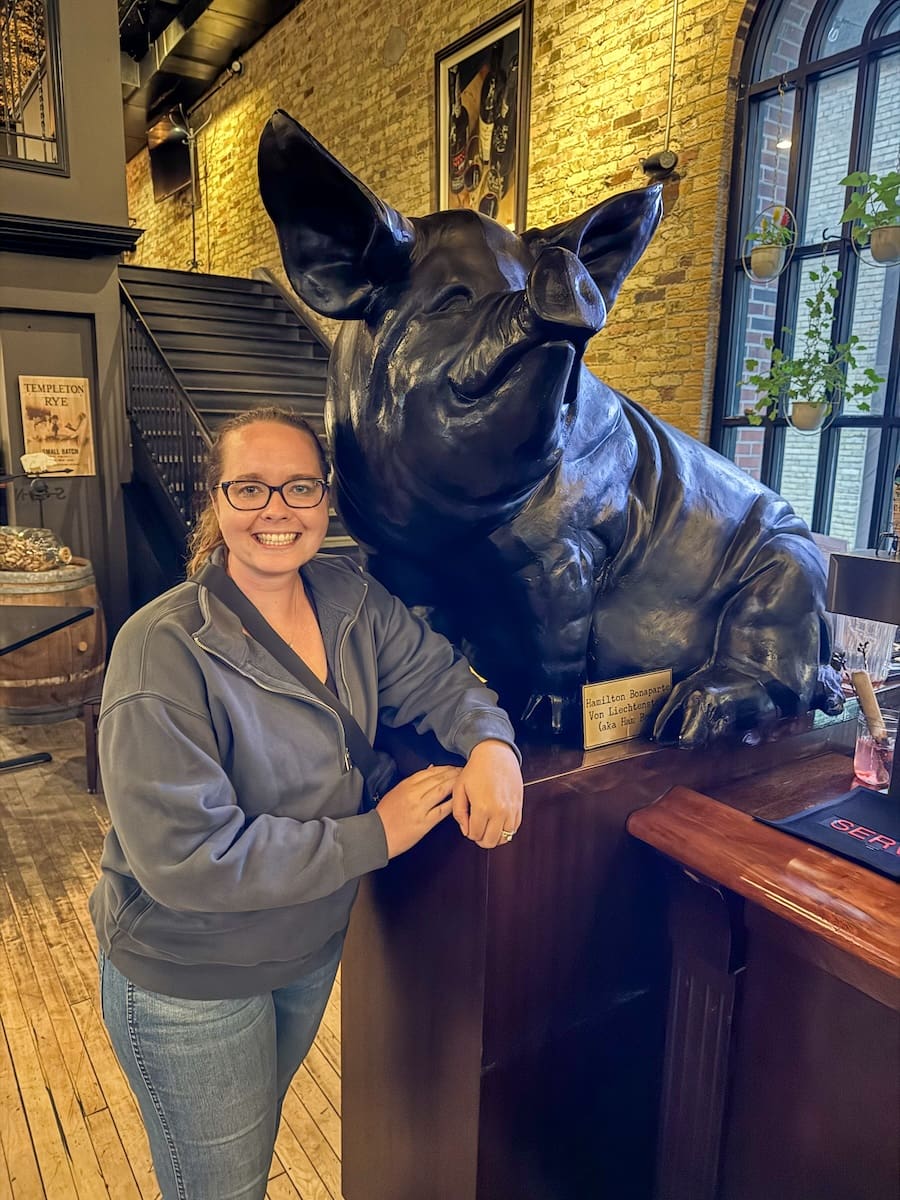 Image of young woman with a black pig statue in Sheboygan, Wisconsin