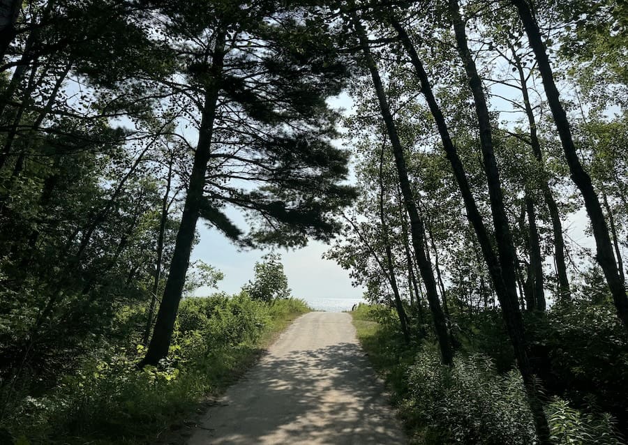 Fall Color Getaways in Wisconsin - Image of tree-lined path to beach at Newport Beach State Park in Door County