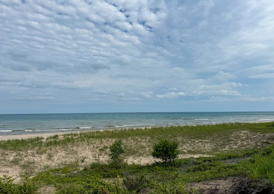 Getaway to Sheboygan - View of cloudy blue sky and the water and surrounding sand dunes at Kohler Andrae State Park.