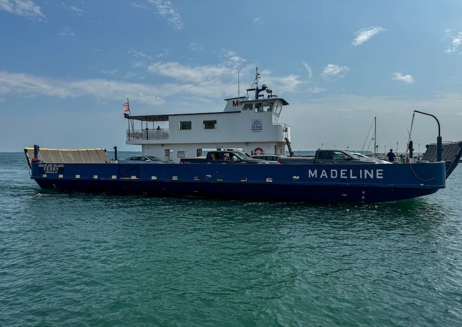 Image of a ferry full of cars on the water. 