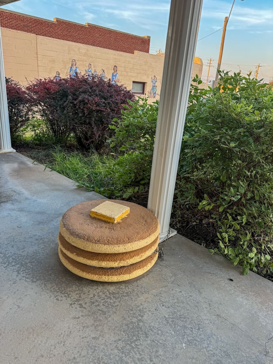 Image of a porch with a stack of fake pancakes with butter on top 