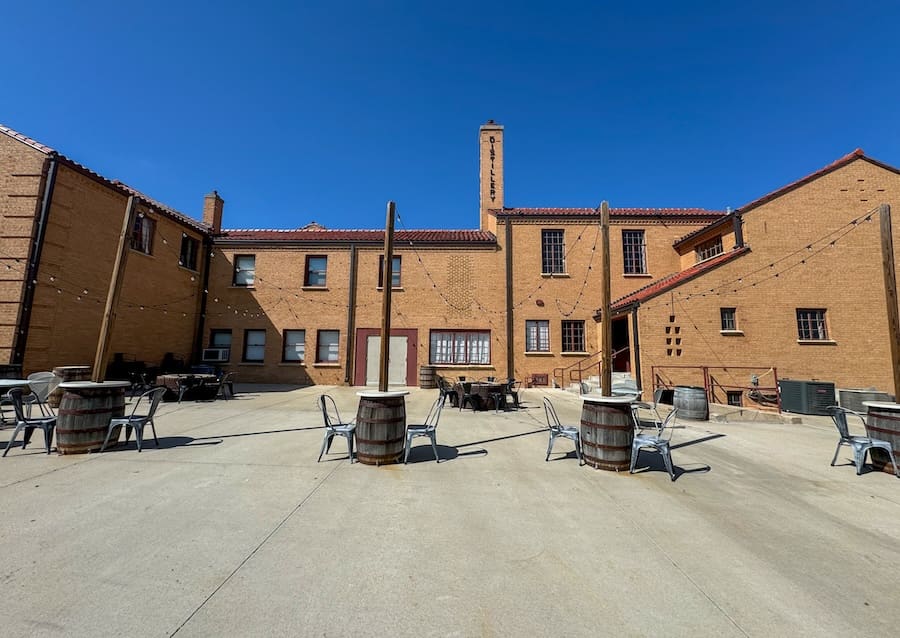 Image of outdoor seating area and back of historic building of Boot Hill Distillery