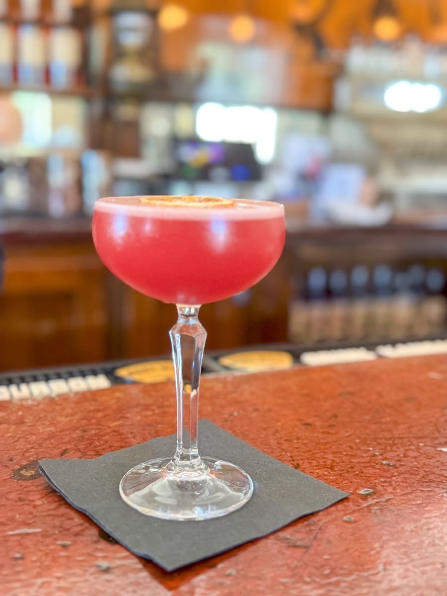 Image of pink whiskey cocktail sitting on bar at the Boot Hill Distillery in Dodge City, Kansas