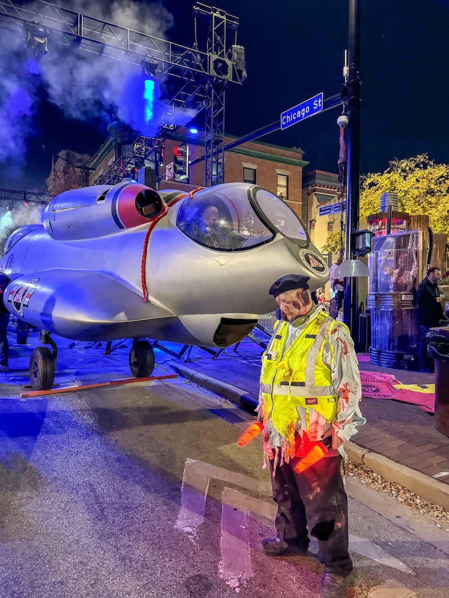 Image of a man dressed up as a zombie next to a plane in downtown Elgin, IL