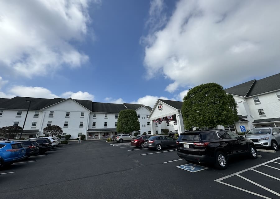 Image of a cloudy blue sky looming over a large white inn - Blue Gate Garden Inn Shipshewana Indiana