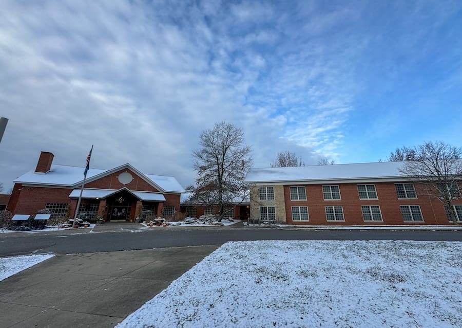 Image of the entrance to the Clifty Inn in Clifty Falls State Park with a cloudy blue sky in the background.