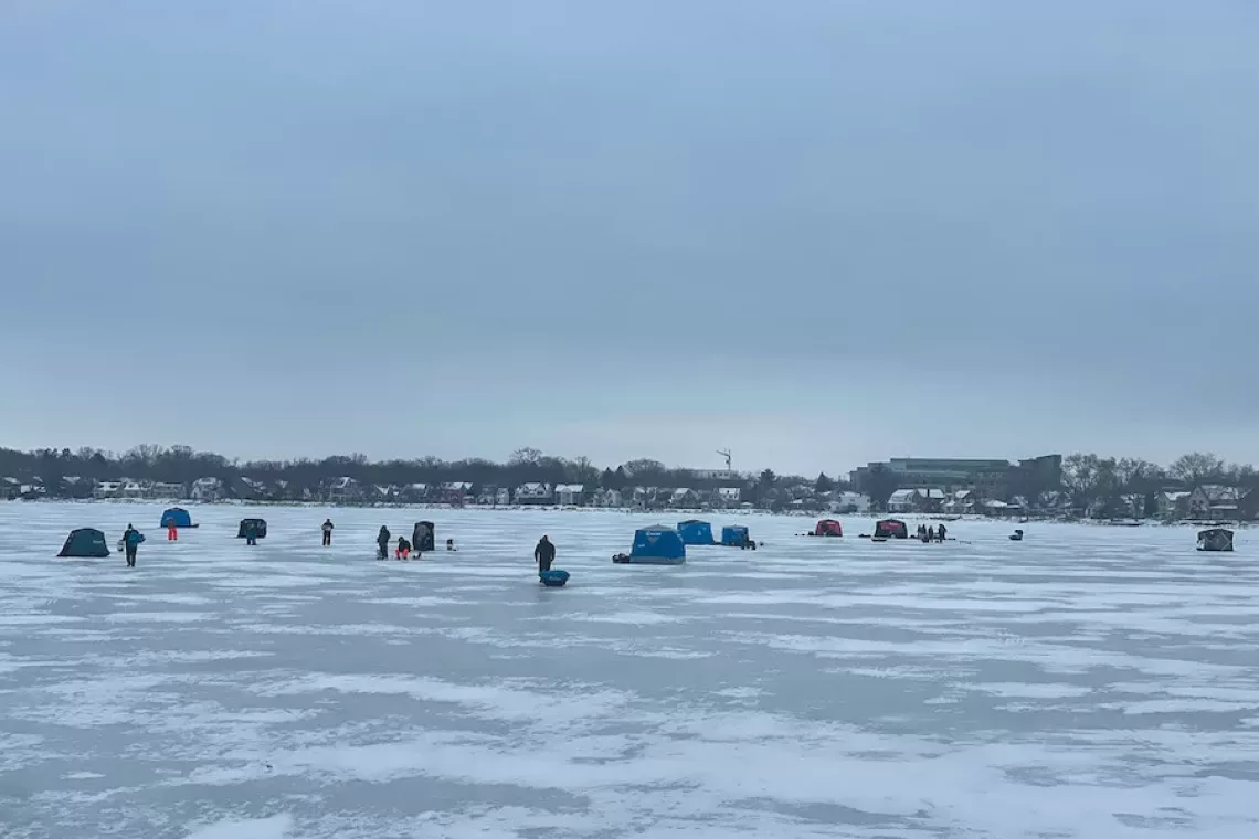 Many individuals and ice shanties fishing on Lake Monona on a dreary day - Winter Outdoor Activities