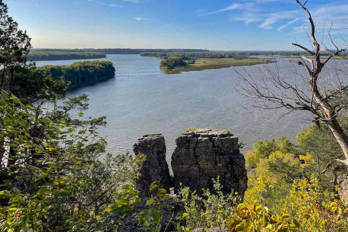 Office to Outdoors Cover - View of Mississippi River and cliff formations surrounded by green foliage from Sentinel Trail in Mississippi Palisades State Park