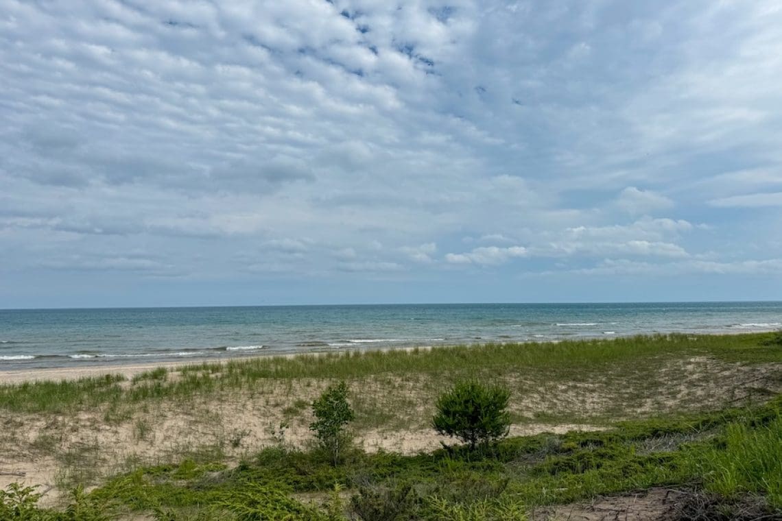 Getaway to Sheboygan - View of cloudy blue sky and the water and surrounding sand dunes at Kohler Andrae State Park.